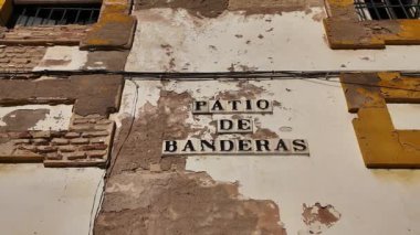 İspanya 'nın Sevilla kentindeki Patio de Banderas tabelasıyla yıpranmış ön cephe, bölgenin zengin tarihi ve mimari detaylarını gözler önüne seriyor