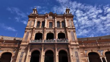 İspanya 'nın Sevilla kentindeki Plaza de Espana merkez binasını ziyaret eden turistler, güneşli bir günde mavi gökyüzü - SEVILLE, SPAIN - 25 Mart 2025