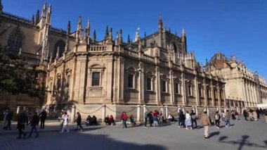 İspanya 'nın Sevilla katedrali yakınlarında yürüyen turistler güneşli bir günde - SEVILLE, SPAIN - 25 Mart 2025