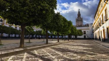 Sevilles cazibesi kaldırım taşı caddelerinde, portakal ağaçlarında ve Giralda kulesinde bulutlu mavi gökyüzünün altında ele geçirildi - SEVILLE, SPAIN - 25 Mart 2025
