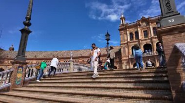 Güneşli bir günde İspanya 'nın başkenti Plaza de Espana' da yürüyen turistler - SEVILLE, SPAIN - 25 Mart 2025