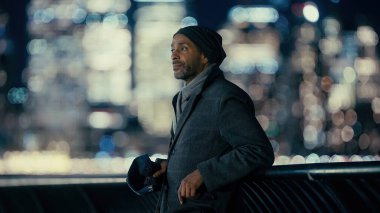 New York, ABD 'de gece vakti parlayan Manhattan siluetine bakan iş adamı.