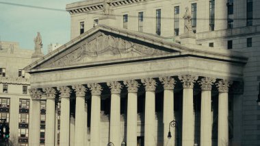 Manhattan, New York 'ta bulunan neoklasik bir bina olan Birleşik Devletler Adliyesi' nin alçak açılı görüntüsü, sütunlarını ve heykellerini vurguluyor.