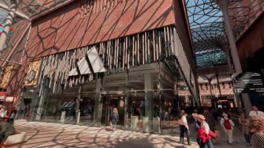 HAMBURG, ALMANY - 29 Nisan 2025 - HafenCity 'deki Adidas mağazasıyla Westfield Hamburg Uberseequartier alışveriş merkezinde yürüyen müşteriler