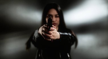 İki eli de silâhlı, geçmişi bulanık genç bir kadın.