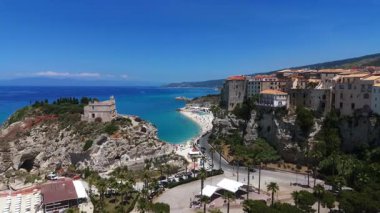 Tropea 'nın havadan görünüşü, Trrhenian Denizi' ne bakan bir uçuruma tünemiş büyüleyici bir kasaba, Santa Maria dellIsola Mabedi, kristal berrak sular, ve canlı plaj