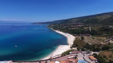 Tropea kıyı şeridinin nefes kesici manzarası canlı Tyrhenian Denizi ile buluşması, beyaz kumlu sahil, turkuaz sular, yemyeşil yemyeşil ve uzak dağlar