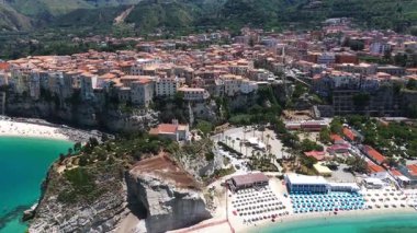 Tropea, İtalya 'nın hava manzarası, renkli plaj şemsiyeleri, uçuruma tünemiş evler ve güzel sahil şeridi.