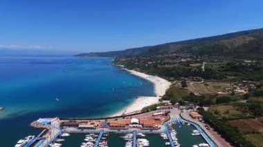 Tropea kıyı şeridinin nefes kesici manzarası canlı Tyrhenian Denizi ile buluşması, beyaz kumlu sahil, turkuaz sular, yemyeşil yemyeşil ve uzak dağlar