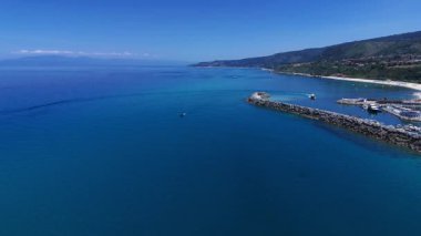 İnsansız hava aracı Tropea 'nın güzel sahil şeridini yakalıyor. Limanı ve berrak sularıyla güneşli bir gökyüzünün altında.