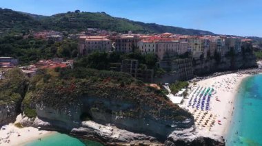 Tropea, Calabria, İtalya 'nın nefes kesici hava manzarası, renkli sahil şemsiyelerini ve eşsiz yamaç kenti mimarisini vurguluyor.