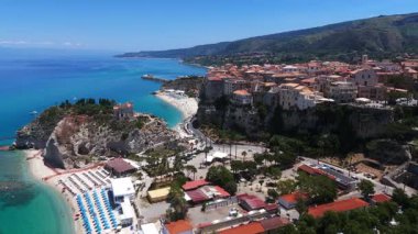 Tropea, Calabria 'nın hava aracı görüntüsü kristal berrak turkuaz suları, plajları ve Santa Maria dellIsola' nın ikonik tapınağı bir uçuruma tünemişti.