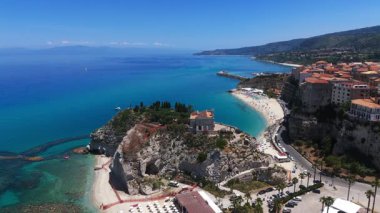 Santa Maria dellIsola Sığınağı 'nın havadan görünüşü, küçük bir adadaki güzel bir kilise, arka planda Tropea plajı ve kasabası görünür.