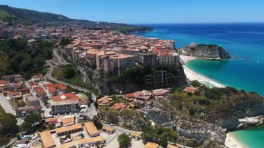 Tropea, Calabria 'nın havadan görünüşü, kumsal, turkuaz deniz ve güneşli bir yaz gününde uçurumun kenarındaki eski bir kasaba.
