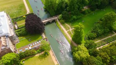 İngiltere 'deki Cambridge Üniversitesi' nin yeşil alanlarından geçen Cam nehrinde gezinen turistlerin hava manzarası