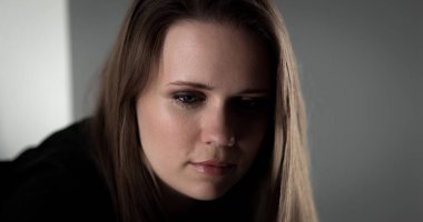 Üzgün bir kadının portresi ağlayan gözlerle aşağıya bakıyor, yalnızlık ve depresyondan muzdarip.