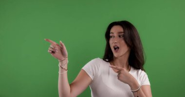 Yeşil ekranda iki işaret parmağı olan genç bir kadın.