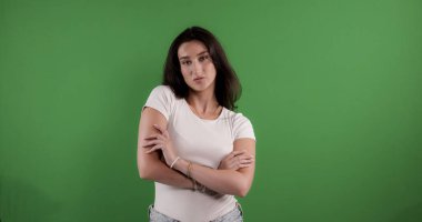 Krom anahtar arka planda kollarını kavuşturan kendinden emin genç bir kadın, reklam ve pazarlama kampanyaları için ideal.