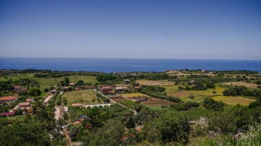 Güney İtalya, Calabria 'da arka planında Tyrhenian Denizi olan Zungri köyünün ekili tarlaları ve evleri