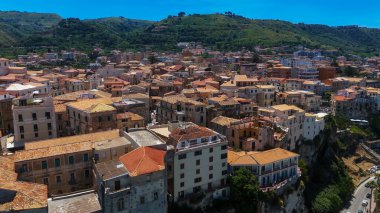 Tropea 'nın panoramik manzarası, güney İtalya' nın Calabria kentindeki Tyrhenia Denizi 'ne bakan, kırmızı kiremit çatılı geleneksel evlere sahip, bir uçuruma tünemiş büyüleyici bir kasaba.