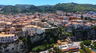 Tropea 'nın havadan görünüşü, Güney İtalya' nın Calabria kentindeki Tyrhenian Denizi 'ne bakan bir uçuruma tünemiş renkli evleri ve yemyeşil bitkileri gösteren büyüleyici bir kasaba.