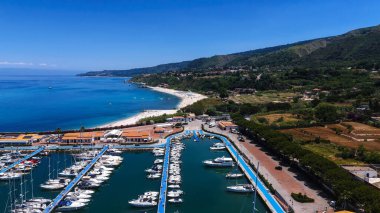 Güney İtalya, Calabria 'nın Tyrhenia sahilinde, rıhtımlı yatları ve güzel beyaz kumlu Tropea limanının hava manzarası.