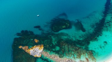 Tropea 'nın kıyı şeridinin nefes kesici manzarası kristal berrak turkuaz suları, kayalık oluşumlar ve canlı deniz yatağını ortaya çıkarıyor.