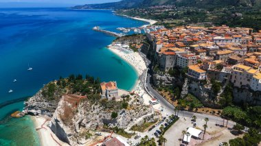 Tropea, Calabria 'nın havadan görünüşü, büyüleyici evleri, güzel plajları ve Tyrhenian Denizi' ne bakan bir uçuruma tünemiş Santa Maria dell 'Isola mabedi.