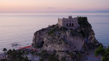 Güney İtalya 'da Tropea, Calabria' da gün batımında Tyrhenian Denizi 'ne bakan kayalık bir uçurumda Santa Maria dell Isola' nın mabedi.