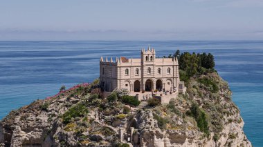 Güneşli bir yaz gününde arka planda mavi Tyrhenian Denizi ile Santa Maria Dell Isola Sığınağı 'nı ziyaret eden turistler