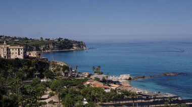 Tropea 'nın panoramik manzarası, Tyrhenian Denizi' ne bakan bir uçuruma tünemiş büyüleyici bir kasaba, kristal berrak turkuaz su ve güneşli bir yaz gününde yelken açan teknelerle dolu.