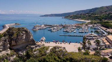 Güney İtalya 'nın Calabria kentindeki Tyrhenian Denizi' ne bakan rıhtımlı tekneleri ve kayalıkları olan Tropea limanının havadan görünüşü güneşli bir yaz gününde