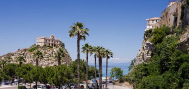 Santa Maria Dell Isola 'nın panoramik manzarası, arka planda palmiye ağaçları ve Tiren Denizi olan küçük bir adada bulunan güzel bir kilise.