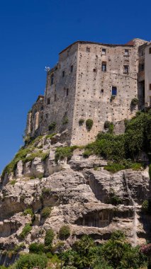 Güney İtalya 'da güneşli bir yaz gününde Calabria' da popüler bir turizm merkezi olan Tropea 'ya bakan bir uçurumun üzerinde duran eski bina.