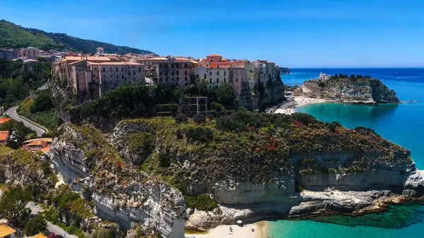 Tropea, İtalya 'nın havadan görünüşü, kayalıklara tünemiş büyüleyici bir kasaba, güneşli bir yaz gününde Tırren Denizi' nin turkuaz sularına bakıyor.