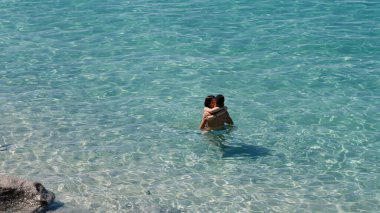 TROPEA, İtalya - Haziran 02, 2025 Güney İtalya 'da popüler bir turizm beldesi olan Calabria' nın güzel turkuaz suyunda kucaklaşan romantik çift