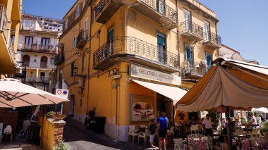 Pizzo, İtalya - 3 Haziran 2025 - Turistler güneşli bir yaz gününde Pizzo, Calabria, İtalya 'da bir açık kafede dondurma yiyorlar