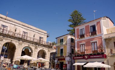 PIZZO, İTALYA - 3 Haziran 2025 - Pizzo, Calabria 'da Meydan' ı işgal eden açık kafeler ve restoranlar, renkli binalar ve açık mavi gökyüzü