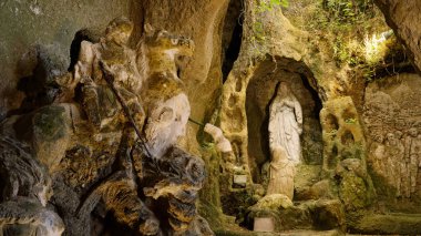 PIZZO, İtalya - 3 Haziran 2025 Güney İtalya 'da Pizzo, Calabria' da bir mağarada Aziz George ve Bakire Meryem 'le savaşan taş heykeller