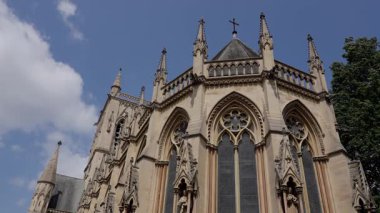 Cambridge, İngiltere 'deki Selwyn Kolej Kilisesi' nin mimari detayları parçalı bulutlu gökyüzüne karşı gotik diriliş tarzı sergiliyor.