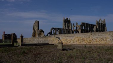 Whitby Abbey 'nin panoramik manzarası Birleşik Krallık' taki Kuzey York Moors Ulusal Parkı 'nda açık mavi bir gökyüzü altında harabeye döndü.