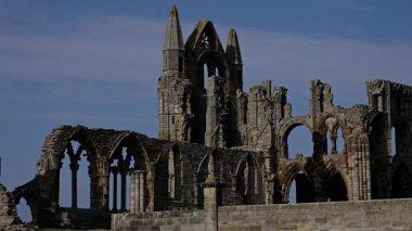 Whitby Abbey 'nin kalıntıları mavi gökyüzüne karşı dimdik duruyor. Kuzey York Moors Ulusal Parkı' nda gotik mimari ve zengin tarihi gözler önüne seriyor.