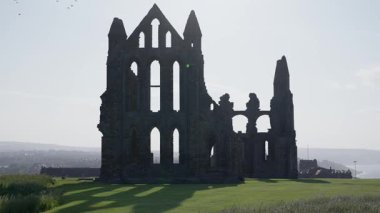 Whitby Abbey 'nin kalıntıları açık gökyüzüne karşı dimdik duruyor, Kuzey York Moors Ulusal Parkı' ndaki tarih ve mimarinin özünü yakalıyor.