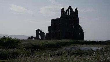 Whitby Abbey 'nin dramatik silueti İngiltere' nin Whitby şehrinde günbatımında manzaraya hakim oldu.