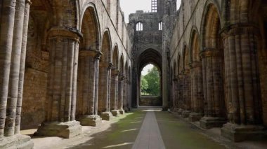 LEEDS, İngiltere - 12 Haziran 2025 - Leeds 'teki tarihi Kirkstall Manastırı' nın içini aydınlatan güneş ışığı, antik mimarisini ve barışçıl atmosferini vurguluyor