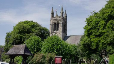 HELMSLEY, İngiltere - 12 Haziran 2025 - All Saints Kilisesi güneşli bir günde Kuzey York Moors Ulusal Parkı 'nda bulunan Helmsley' deki yemyeşil yemyeşil alanda dimdik ayakta duruyor