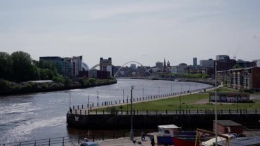 NEWCASTLE, İngiltere - 13 Haziran 2025 - Güneşli bir günde Tyne Nehri üzerinde yükselen Milenyum Köprüsü ile Tyne şehir merkezindeki Newcastle 'ın panoramik görüntüsü