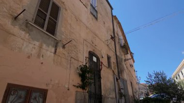 Tropea, İtalya 'daki tarihi bir binanın dış cephesinde zaman ve güneşin renkli duvarları üzerindeki etkilerini gösteriyor.