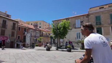 TROPEA, İtalya - 2 Haziran 2025 Güney İtalya 'nın Calabria şehrinde güneşli bir yaz gününde scooter' la gezen denizci Tropea 'yı keşfediyor.