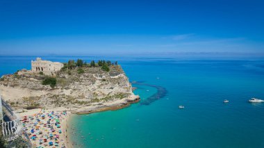 Güney İtalya, Calabria 'daki Santa Maria dell Isola Sığınağı ile Tropea sahilinde dinlenen turistler